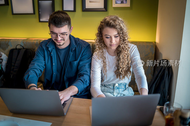 Business people working together at a café using their laptops